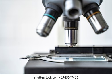 close up microscope stage and objectives researching corona virus microscopic cells behavior testing vaccination cure, in medical center lab world health organization research facilities