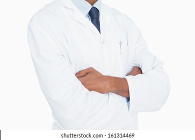 Close up mid section of a male doctor with arms crossed against white background