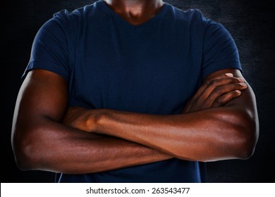 Close Up Mid Section Of Man With Arms Crossed Against Black Background