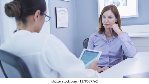 Close Up Of Mid-aged Female Patient Chatting With Doctor Indoors Office Setting