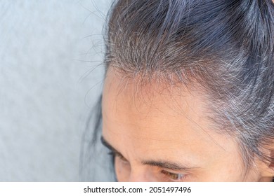 Close Up Of Middle Age Caucasian Woman With Dark Brown Hair And Regrown Gray Hair Roots