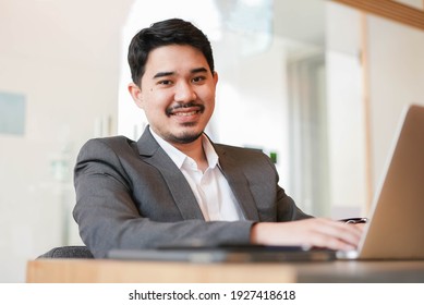 Close Up Middle Eastern Adult Businessman Sitting At Table While Working On Laptop In Office Room For Business Service Lifestyle Concept