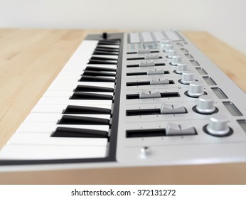 Close up of MIDI controller volume fader, knob and keys.