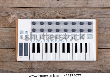 Close up of MIDI controller volume fader, knob and keys.