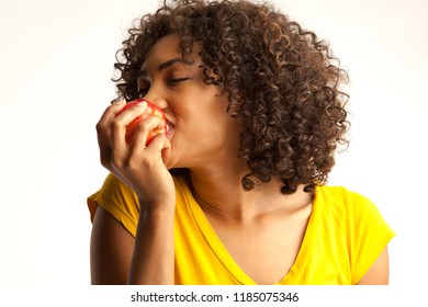 Close up of millennial woman enjoying fresh red apple isolated on white