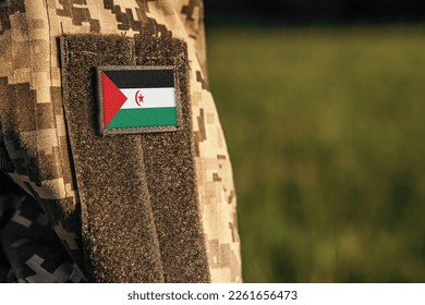 Close up millitary woman or man shoulder arm sleeve with Western Sahara flag patch. Western Sahara troops army, soldier camouflage uniform. Armed Forces, empty copy space for text

