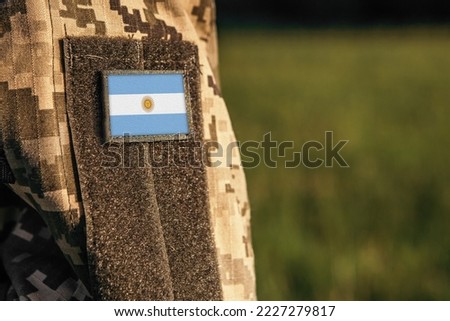 Close up millitary woman or man shoulder arm sleeve with Argentina flag patch. Argentina troops army, soldier camouflage uniform. Armed Forces, empty copy space for text
