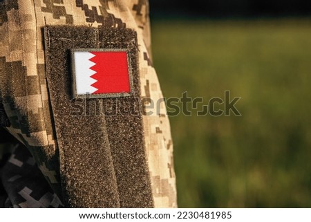 Close up millitary woman or man shoulder arm sleeve with Bahrain flag patch. Bahrain troops army, soldier camouflage uniform. Armed Forces, empty copy space for text

