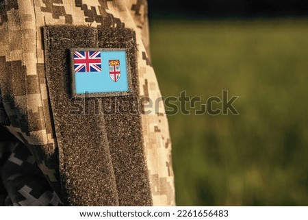 Close up millitary woman or man shoulder arm sleeve with Fiji flag patch. Fiji troops army, soldier camouflage uniform. Armed Forces, empty copy space for text

