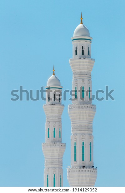 Close up the minarets\
of the Hazrat Sultan Mosque. Islamic religious architectural\
traditions. Mosque architecture. Kazakhstan, Central Asia. Isolated\
on blue background.