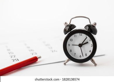 Close up of mini alarm clock, calendar and red pen on white background. Business meeting planning, deadline concept. - Powered by Shutterstock