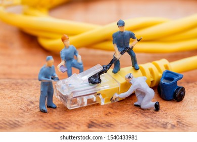 Close up miniature technician teamwork maintenance rj45 with network cable. telecommunication concept.   - Powered by Shutterstock