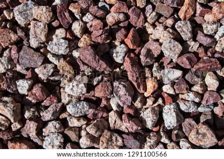 Close up of Mixed Pile of Gravel, Granite, Stone in Hard Light