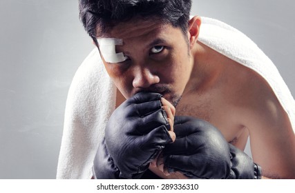 Close up of MMA fighter looking at camera with powerful stare, on grey background - Powered by Shutterstock