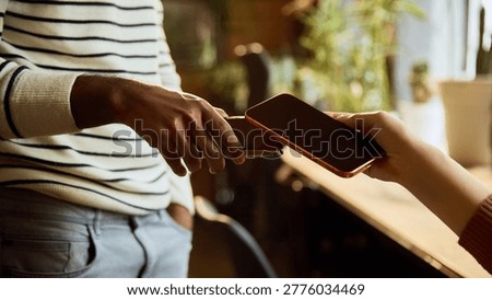 Close up of mobile banking payment between two smartphones. Concept of peer to peer transfer, contactless transaction, shared expenses, fintech service and secure cashless payment.