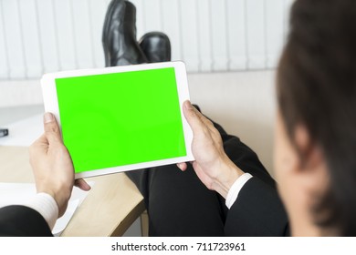 Close Up The Mock Up With Green Screen On Display Of White Tablet In Businessman Keeping Legs On Table, Holding And Touchscreen In Relaxing Time
