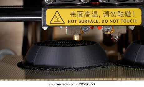 Close up of a modern 3D printer. Head of 3d printer in action. Close Up Of 3D Printer Operating In Design Studio - Powered by Shutterstock