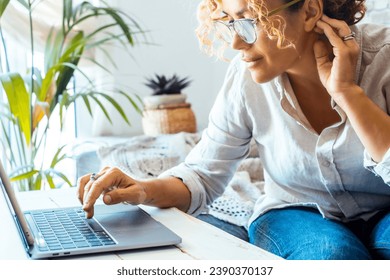 Close up of modern businesswoman writing on laptop at home office workplace. Small business and female entrepreneur job activity. Female people writing on computer on the table wearing glasses alone