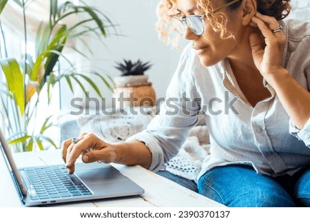 Close up of modern businesswoman writing on laptop at home office workplace. Small business and female entrepreneur job activity. Female people writing on computer on the table wearing glasses alone