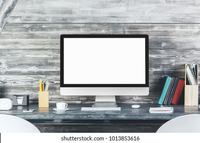 Close up of modern desk top with blank white computer monitor, stationery items and other objects. Design and advertisement concept. Mock up 