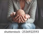 Close up mom gently cradling and rocking newborn baby in arms. Focus on hands holding baby, capturing tender, intimate moment of maternal care and love