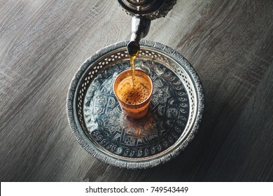 Close Up Of Moroccan Traditional Tea Pot And Glass On A Silver Plate