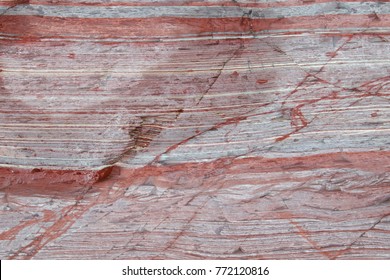 Close Up Of Mostly Red Sediment Layers In A Rock Formation.