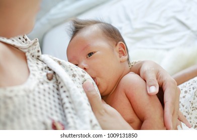 Close up mother breast feeding her newborn child.