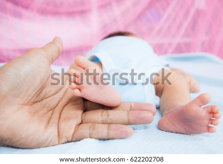 Close up mother hand holding tiny  baby foot 