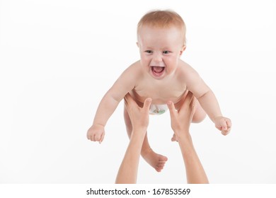 Close Up Of Mother Hands Throwing Up Little Baby. Cute Baby Laughing Isolated Over White Background 