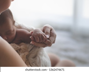 Close Up Mother Holding Hands Asian Female Newborn Baby  And Sunlight In The Morning. Cute Little Girl  Three Weeks Old. Health, Care, Love, Relationship Concept.