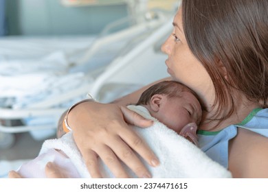 Close up of mother holding a sleeping newborn baby in the bed of a hospital room. Healthcare medical love woman lifestyle mother's day, breast concept with copy space - Shutterstock ID 2374471615