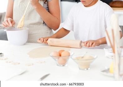 Close Up Of Mother And Son Preparing A Dough Together In The Kitchen