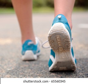 Close Up Motion Shot Of Person Walking Away In Running Shoes