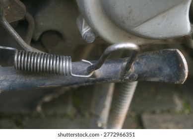 close up of a motorcycle kickstand and its return spring                               