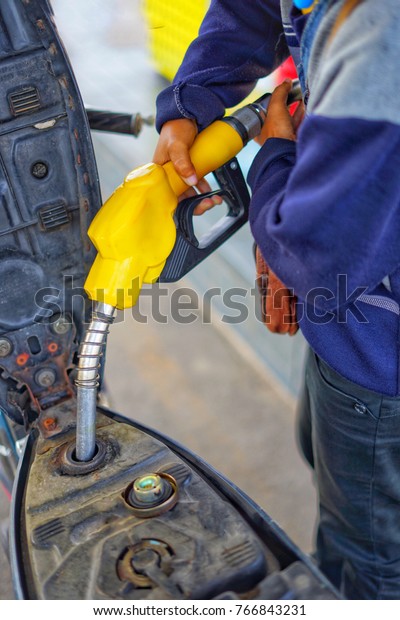    close up to motorcycle park\
refueling in petrol station.                           \
