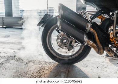 Close up of motorcycle wheel burnout at parking.