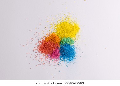 Close up of multi coloured sand and copy space on white background. Sand, texture, movement, shape and colour concept.
