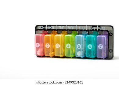 Close Up Of A Multicoloured Plastic Daily Pill Dispenser On White Background