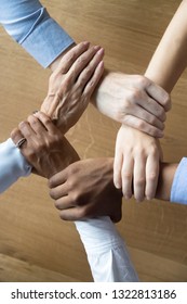 Close up multiracial business people holding each others wrists, join hands together, support and unity, team strength and power, colleagues involved in team building activity, vertical photo