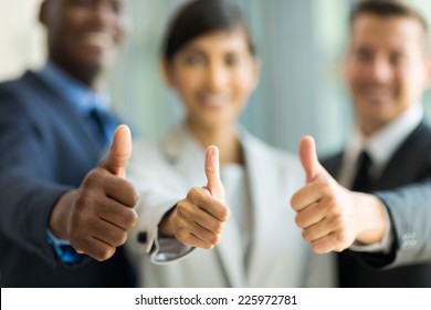 close up of multiracial business team giving thumbs up