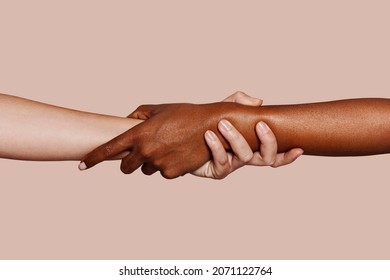Close up multiracial woman couple with black and caucasian hands holding each other wrist in tolerance unity love and anti racism concept - Shutterstock ID 2071122764