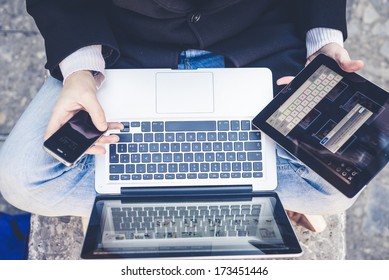 close up multitasking man using tablet, laptop and cellphone connecting wifi in the city street urban - Powered by Shutterstock