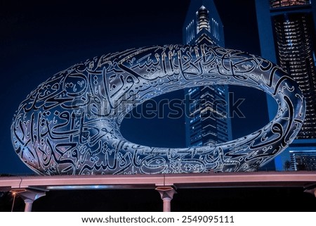 Close up of Museum of the future on Sheikh Zayed Road in Dubai at night. Tall high modern skyscrapers.

Translation: 