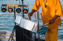 Close Up Of A A Musician From Jamaica Playing Steel Pan Drums On The Open Deck Of A Tourist Boat In Key West, Florida.	
