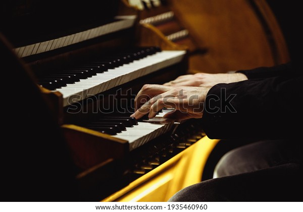 Close up of
musician's hands playing the
organ.