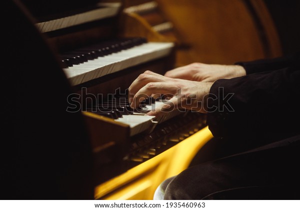Close up of\
musician\'s hands playing the\
organ.