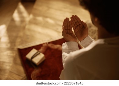 Close up of Muslim believer reciting dua during prayer at home.