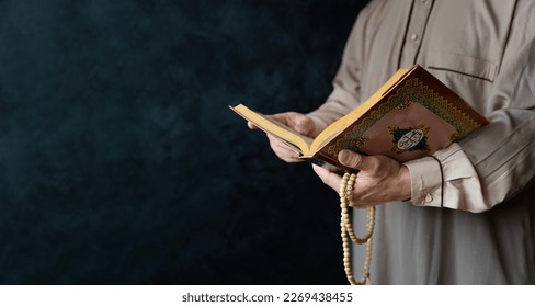 Close up of a Muslim man reading holy quran. Muslim mans hands praying and holding prayer beads. Written in Arabic, it means that Muhammad is the Prophet in Islam. - Powered by Shutterstock
