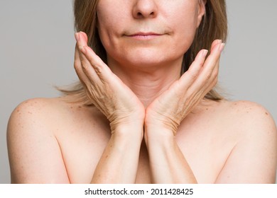 Close Up Of The Neck, Hands And Naked Shoulders Of A Caucasian Mature Woman With A Healthy Glowing Skin And Body